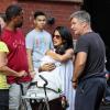 Alec Baldwin et sa femme Hilaria Thomas (très enceinte) câlinent le bébé d'A.J. Calloway (un journaliste de l'émission Extra) dans les rues de New York, le 21 août 2013.