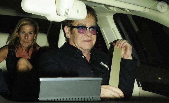 Elton John quittant l'Aqua Club après avoir reçu le Brits Icon Award au London Palladium à Londres, le 2 septembre 2013.