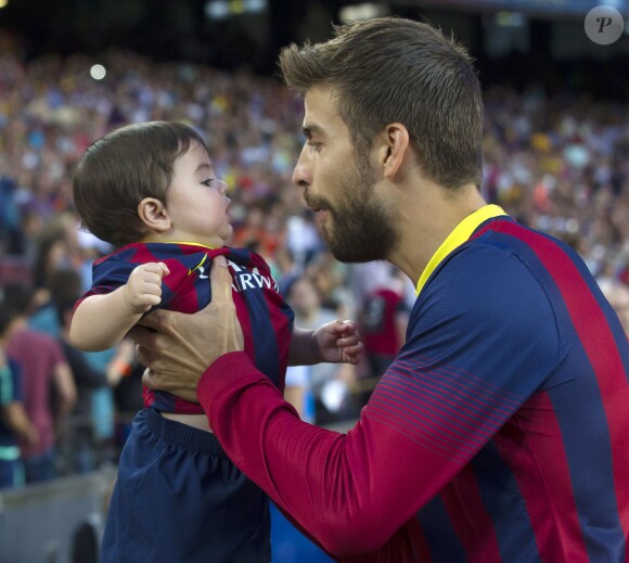 Gerard Piqué avec Shakira et son fils Milan lors du match FC Barcelone - Seville à Barcelone, le 14 septembre 2013.