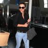 Miranda Kerr arrive a l'aéroport de Los Angeles, habillée d'un top The Row, d'un jean Frame Denim et de balleries Balenciaga. Des lunettes Stella McCartney et un sac Balmain par Aurélie Bidermann accessoirisent sa tenue. Le 21 octobre 2013.