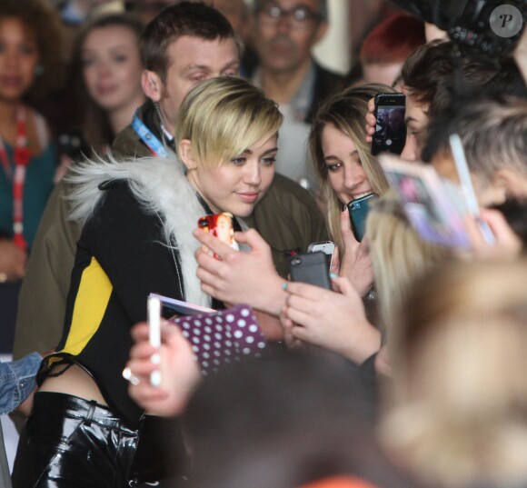 Miley Cyrus quitte les studios de la BBC Radio 1 à Londres, en n'oubliant pas de saluer et de poser avec ses fans qui l'attendaient à la sortie. Le 12 novembre 2013.