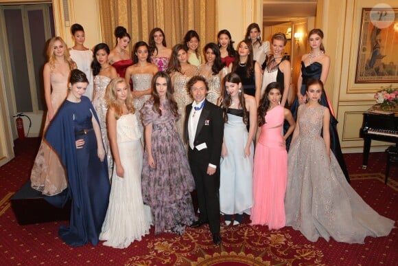 Stéphane Bern entouré, le 30 novembre 2013 à l'Automobile Club de France à Paris, des vingt héroïnes du Bal des Débutantes, habillées par des maisons de couture différentes et parées de bijoux de la Maison Bucherer.