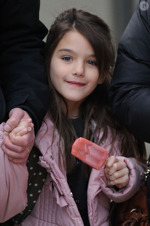La jolie Suri Cruise, glace à la main, à la sortie de son école à New York le 11 décembre 2013.