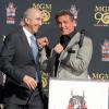 Sylvester Stallone et le directeur de la Metro-Goldwyn-Mayer, Gary Barber, lors de la cérémonie des empreintes de la MGM devant le TCL Chinese Theatre avec sa mascotte le lion Leo, le 22 janvier 2014 à Los Angeles.