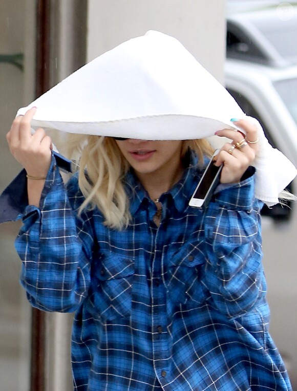 Rita Ora se protège de la pluie dans les rues de Los Angeles, le 6 février 2014.