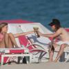 Georgia May Jagger et un ami se détendent à la plage à Miami le 05/02/2014. Le top model a passé le plus clair de son temps à écouter de la musique et lire les magazines people.