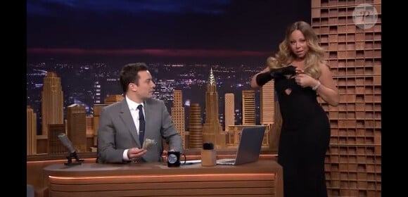 Mariah Carey offre 100 dollars à Jimmy Fallon lors de sa première au Tonight Show, le 17 février 2014.