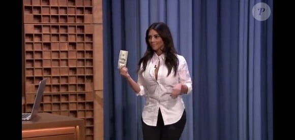 Kim Kardashian offre 100 dollars à Jimmy Fallon lors de sa première au Tonight Show, le 17 février 2014.