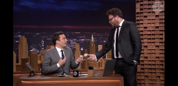 Seth Rogen offre 100 dollars à Jimmy Fallon lors de sa première au Tonight Show, le 17 février 2014.