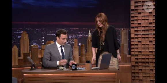 Lindsay Lohan offre 100 dollars à Jimmy Fallon lors de sa première au Tonight Show, le 17 février 2014.