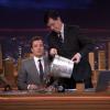 Stephan Colbert offre 100 dollars à Jimmy Fallon lors de sa première au Tonight Show, le 17 février 2014.