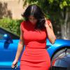 Kim Kardashian, vêtue d'une robe rouge, arrive pour déjeuner avec son fiancé Kanye West au restaurant Nobu à Malibu, le 14 mars 2014.
