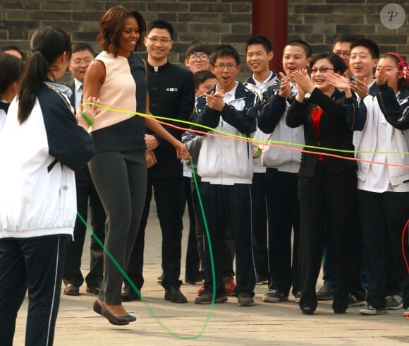 Michelle Obama fait du saut à l'élastique lors d'une visite dans la ville fortifiée de Xian dans la province de Shaanxi en Chine, le 24 mars 2014.