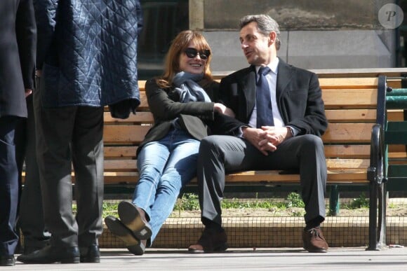 Nicolas Sarkozy et sa femme Carla Bruni se prélassent sur un banc du lycée de leur bureau de vote dans le 16e arrondissement à Paris. Le 23 mars 2014.