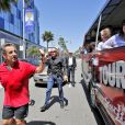 Exclusif - Nicolas Sarkozy se fait arrêter par un bus touristique du site d'infos people TMZ.com lors de son jogging à Beverly Hills, le 28 avril 2014. L'ancien président amusé par cette situation inattendue, salue les touristes et pose devant leurs objectifs.