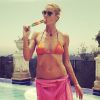 Heidi Klum en bikini et paréo, déguste une glace près de sa piscine.