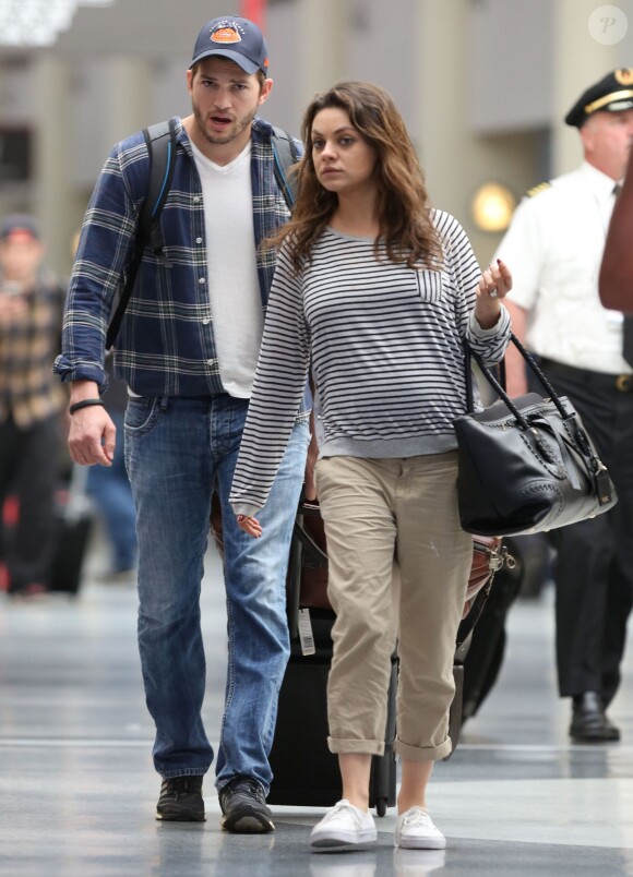 Exclusif -  Mila Kunis, enceinte, et son fiancé Ashton Kutcher arrivent à l'aéroport de La Nouvelle-Orléans pour prendre l'avion. Le 19 avril 2014.