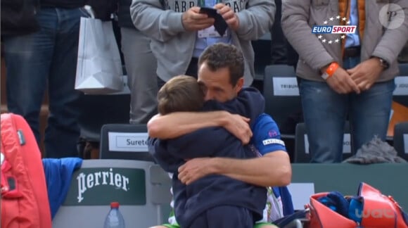 Michaël Llodra dans les bras de son fils Théo lors des ses adieux à Roland-Garros, le 27 mai 2014 à Paris