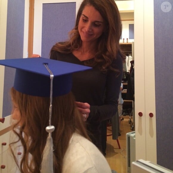 Rania de Jordanie ajustant les derniers détails de la tenue de sa fille la princesse Iman le 4 juin 2014 avant la cérémonie de remise de son diplôme de fin d'études, à Amman.