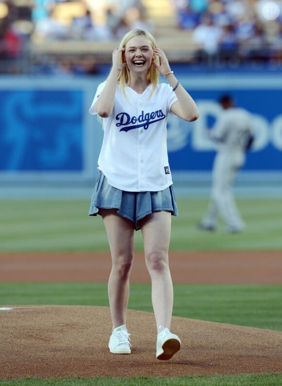 Elle Fanning, invitée star au Dodger Stadium, porte un maillot de l'équipe des Los Angeles Dodgers, un short plissé en jean et des baskets adidas (modèle Stan Smith). Los Angeles, le 4 juin 2014.