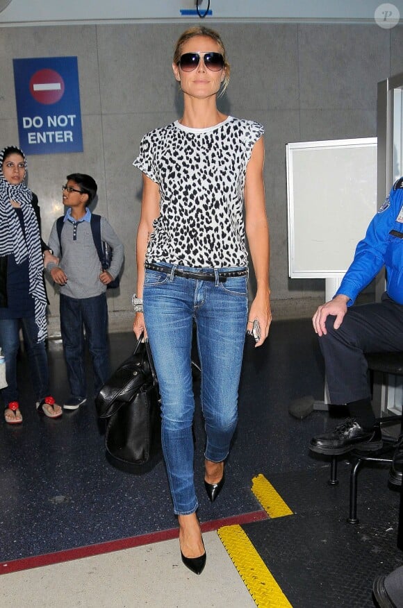 Heidi Klum arrive à l'aéroport de Los Angeles, habillée d'un t-shirt léopard et d'une ceinture Saint Laurent, d'un jean Citizens of Humanity, d'un sac Versace (modèle Palazzo) et de souliers noirs. Le 4 juin 2014.