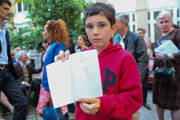 Exclusif - Nathan, fier de sa dédicace de Sempé - Vernissage de l'exposition "Les vacances du petit Nicolas" à la mairie du 4ème à Paris le 18 juin 2014.