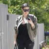Kim Kardashian, de retour à Los Angeles après un passage à Cannes, porte des lunettes de soleil Céline, une veste Fear of God, un top et un jean noirs, un sac Hermès (le Birkin) et des souliers Saint Laurent. Le 19 juin 2014.
