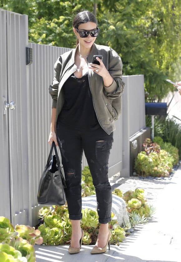 Kim Kardashian, de retour à Los Angeles après un passage à Cannes, porte des lunettes de soleil Céline, une veste Fear of God, un top et un jean noirs, un sac Hermès (le Birkin) et des souliers Saint Laurent. Le 19 juin 2014.
