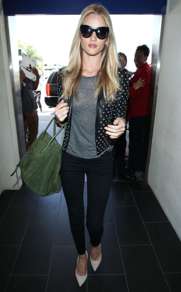 Rosie Huntington-Whiteley à l'aéroport de Los Angeles, porte des lunettes de soleil Dolce & Gabbana, une veste Saint Laurent, un top gris et un slim noir, un sac Céline (modèle Luggage) et des souliers Manolo Blahnik. Le 15 juin 2014.