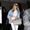 Rosie Huntington-Whiteley à l'aéroport LAX, porte des lunettes Dolce & Gabbana, un sac Givenchy (modèle Antigona), un jean blanc Siwy et des souliers Manolo Blahnik. Le 20 juin 2014.