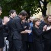 Elisabeth Duquesne, veuve de Benoît Duquesne, et leurs quatre enfants ont applaudi avec une immense émotion et beaucoup de fierté à la sortie du cercueil lors des obsèques du journaliste, à l'église Jeanne d'Arc de Versailles, le jeudi 10 juillet 2014.
