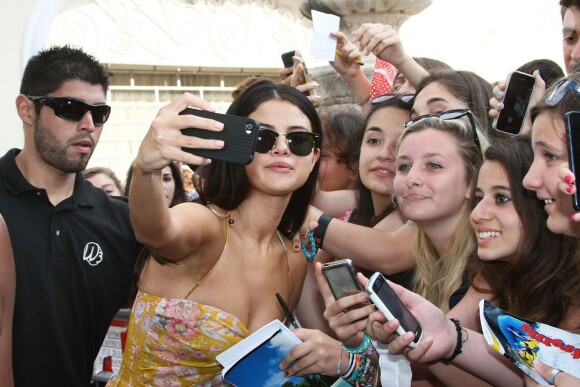 Selena Gomez pose avec des fans et leur signe des autographes, lors du festival d'Ischia en Italie, le 18 juillet 2014.