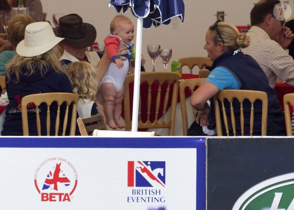 Autum Phillips aide sa velle-soeur Zara Phillips à changer sa fille Mia, 6 mois, lors du 2e jour du Festival du concours complet britannique à Gatcombe Park, le 2 août 2014.