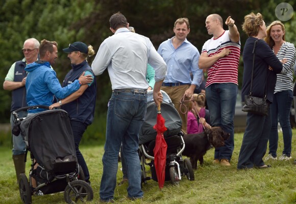 Zara Phillips et son mari Mike Tindall, avec leur fille Mia, retrouvent des proches le 2 août 2014 à Gatcombe Park lors du Festival du concours complet britannique.