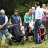 Zara Phillips et Mike Tindall, avec leur fille Mia en poussette, retrouvent des proches le 2 août 2014 à Gatcombe Park lors du Festival du concours complet britannique.