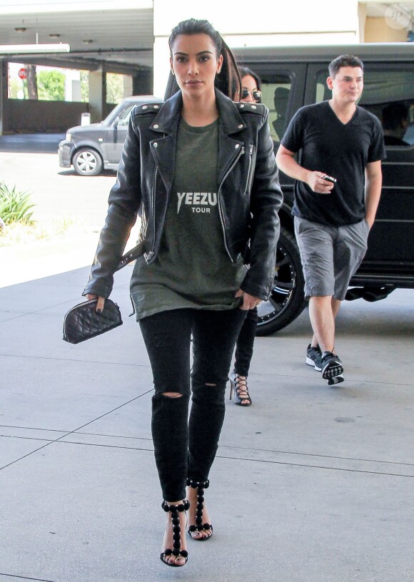 Kim Kardashian se rend au centre commercial de Topanga à Woodland Hills, habillée d'une veste en cuir BLK DNM, d'un t-shirt Yeezus (dérivé de la tournée Yeezus Tour de Kanye West), d'une pochette matelassée Chanel, d'un jean noir et de sandales Azzedine Alaïa. Le 5 août 2014.