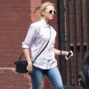 Naomi Watts se balade à New York, habillée d'une chemise blanche et d'un jean zippé, d'un petit sac Gucci (modèle soho disco) et de sandales Birkenstock. Le 21 août 2014.