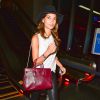 Lily Aldridge surprise à l'aéroport LAX de Los Angeles, porte un chapeau rag & bone, un débardeur blanc, un pantalon en cuir noir, d'un sac (modèle Petit Sac de Jour) et de bottines Saint Laurent. Le 19 août 2014.