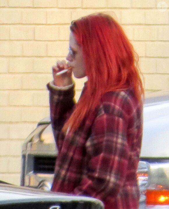 Kristen Stewart, les cheveux rouges, fume une cigarette sur le tournage du film "American Ultra" à La Nouvelle-Orleans. Le 15 avril 2014