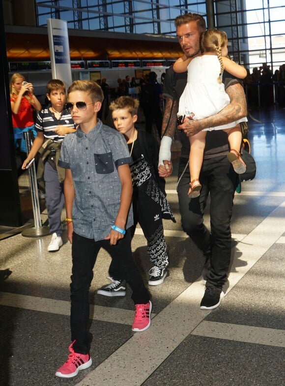 David Beckham et ses enfants Romeo, Cruz, et Harper surpris à l'aéroport LAX à Los Angeles, le 29 aout 2014