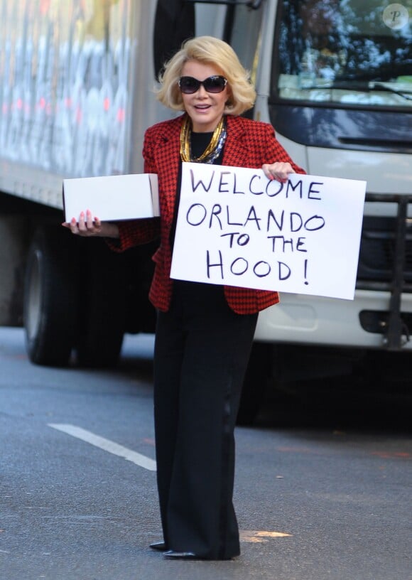 Joan Rivers accueille Orlando Bloom avec un gâteau et une pancarte dans son quartier de New York le 29 Octobre 2013