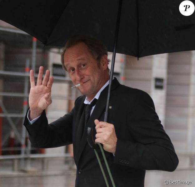 Exclusif - Benoît Poelvoorde promène son chien sous la pluie place Vendôme à Paris le 3 août 2014.