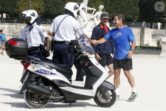L'ex-président Nicolas Sarkozy en train de faire son jogging avec ses gardes du corps au jardin des Tuileries, le 10 septembre 2014, à Paris.