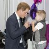 Le prince Harry discute avec le petit Carson Hartley lors de la cérémonie des 10e WellChild Awards, le 22 septembre 2014 au Hilton de Londres, remis par l'association WellChild qui soutient les enfants malades, dont il est le parrain depuis 2007.