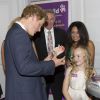 Le prince Harry ravi de recevoir en cadeau une tirelire de cochon à son image lors de la cérémonie des 10e WellChild Awards, le 22 septembre 2014 au Hilton de Londres, remis par l'association WellChild qui soutient les enfants malades, dont il est le parrain depuis 2007.