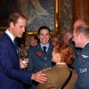Le prince William, le prince Harry et Elizabeth II, lors de la réception en l'honneur de soldats blessés au combat et revenus à présent à la vie militaire au palais de Buckingham à Londres, le 6 novembre 2014.