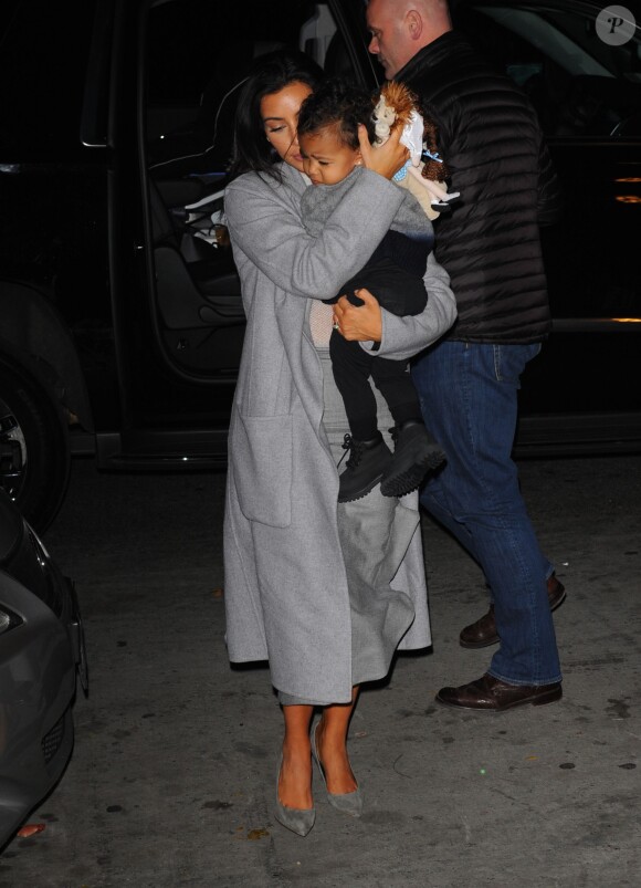 Kim Kardashian, habillée d'un manteau Céline et chaussée de souliers Saint Laurent, rentre chez elle avec sa fille North. New York, le 7 novembre 2014.