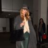 Rosie Huntington-Whiteley à l'aéroport LAX, porte un manteau The Row, un pantalon Balenciaga, un pull en cachemire Acne, un sac Saint Laurent et des bottines Azzedine Alaïa. Los Angeles, le 9 novembre 2014.