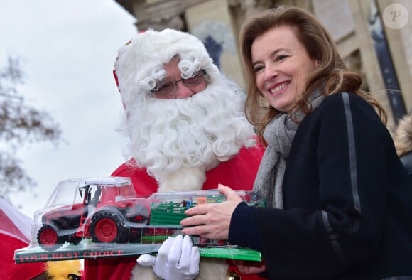 Valérie Trierweiler et le Père Noël - Distribution des cadeaux de Noël aux enfants du Secours Populaire sur les Champs-Elysées à Paris, le 20 décembre 2014. 