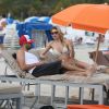 Le top model Martha Hunt et un ami se détendent sur une plage de South Beach, à Miami. Le 21 décembre 2014.